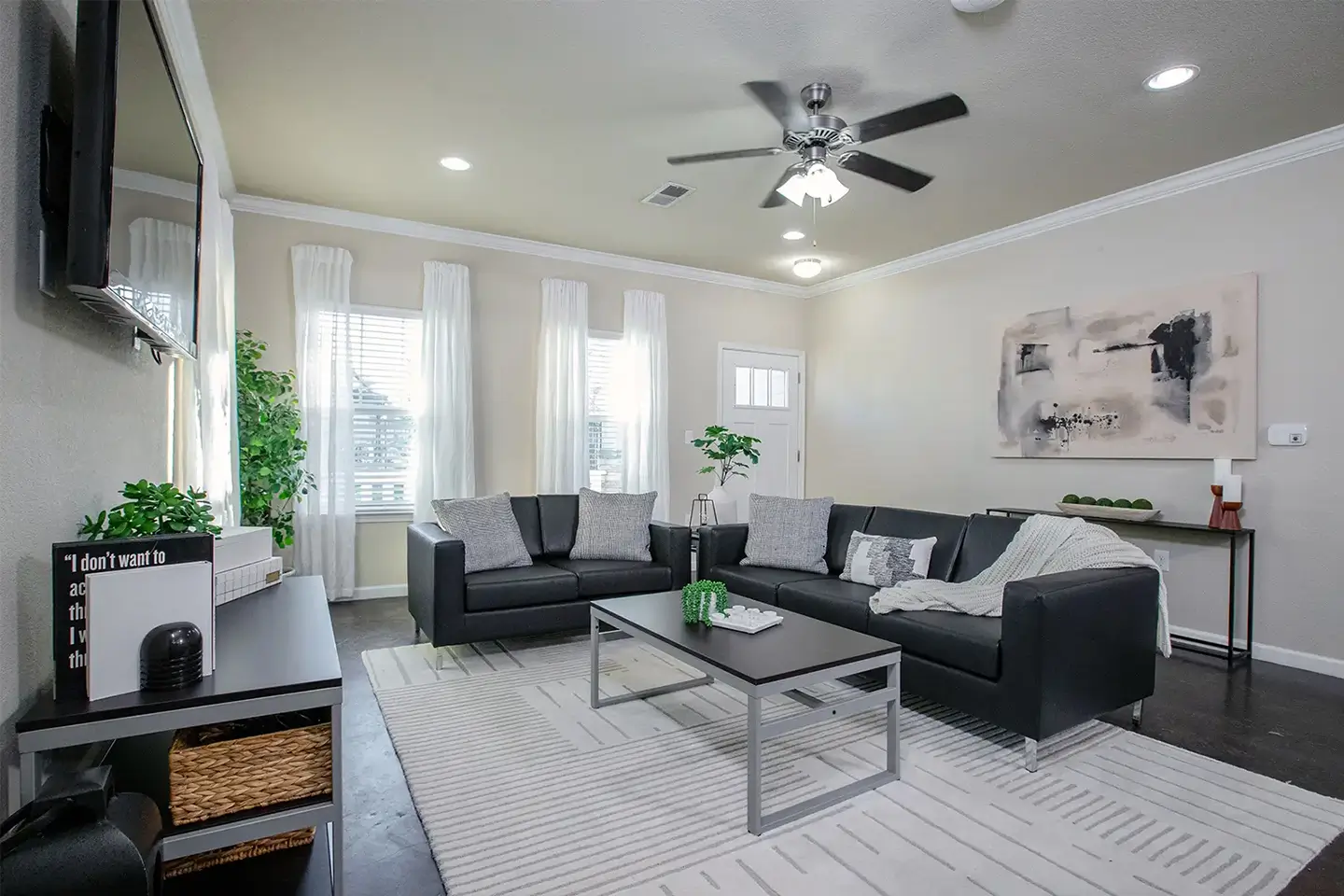 Furnished living room with couches, coffee table, and TV.